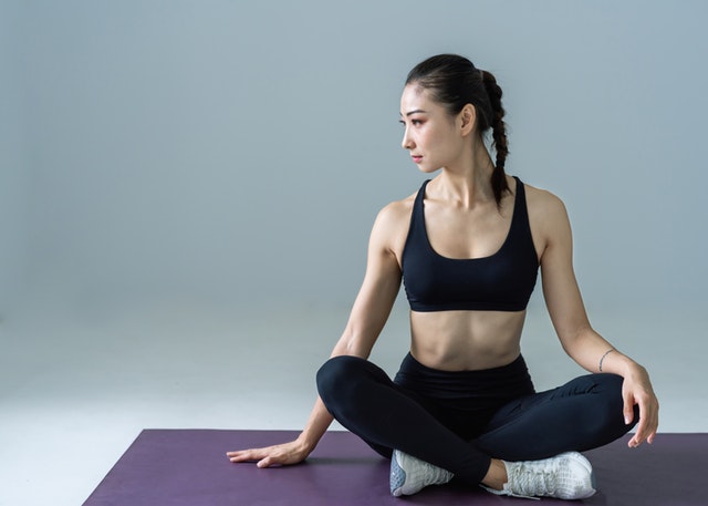 woman-sitting-on-yoga-mat-2294352
